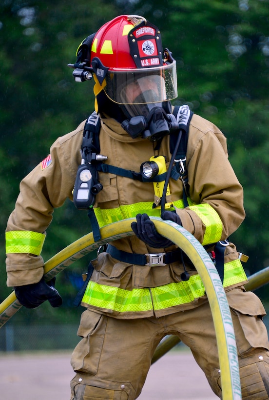 Nebraska Army National Guard Sgt. Marco Flores holds a fire hose during an aircraft rescue and fire burn to prepare for the annual Patriot 2015 Exercise at Volk Field Combat Readiness Training Center, Wis., July 16, 2015. Flores is a firefighter assigned to the 317th Engineer Detachment.