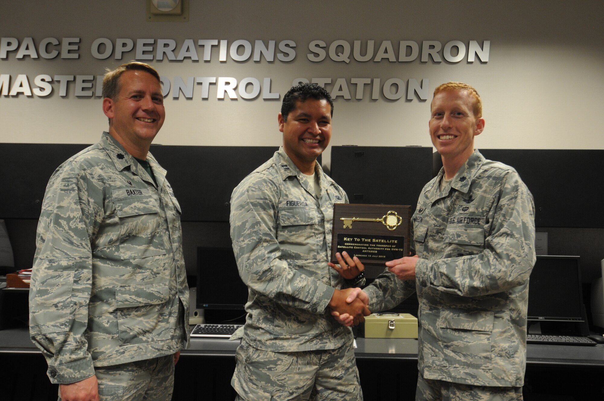 Lt. Col. Sam Baxter (left), 19th Space Operations Squadron commander, alongside Capt. Brian Figueroa, Global Positioning System Directorate Lead GPS IIF mission operations engineer, pass Satellite Control Authority to Lt. Col. Todd Benson, 2nd Space Operations Squadron commander during a transfer ceremony of the tenth Global Positioning System Block IIF satellite at Schriever Air Force Base Friday, July 24, 2015. The members of 2 and 19 SOPS operate the largest Department of Defense satellite constellation via the Master Control Station and a worldwide network of monitoring stations and ground antennas. (U.S. Air Force photo/2nd Lt. Darren Domingo)