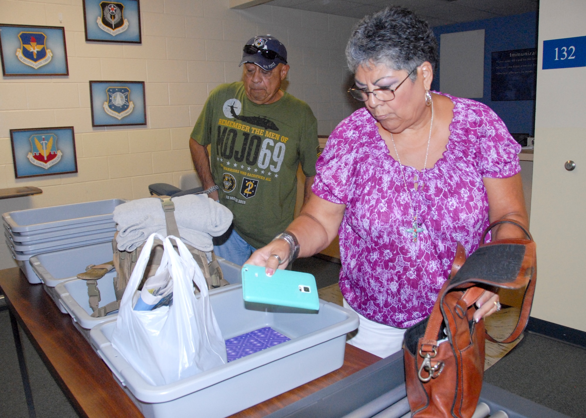 Retired Tech. Sgt. Alex Yepez and his wife, Maggie, collect their carry-on items following screening at the Eglin passenger terminal.  The terminal follows all guidelines set forth by the Transportation Security Administration.  (U.S. Air Force photo/Kevin Gaddie)
