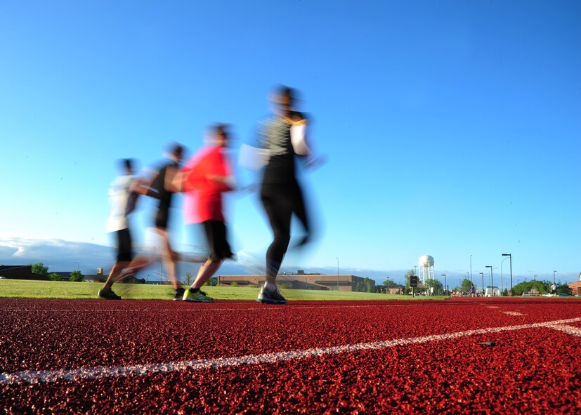 Airmen run through the turn during the Grand Forks Air Force Base 12-hour Relay July 24, 2015. Airmen competed as either a team or individually and collected pledges to raise money for the Wounded Airman Program. Teams were required to have at least one person running at all times during the event. (U.S. Air Force photo by Airman 1st Class Ryan Sparks/released)