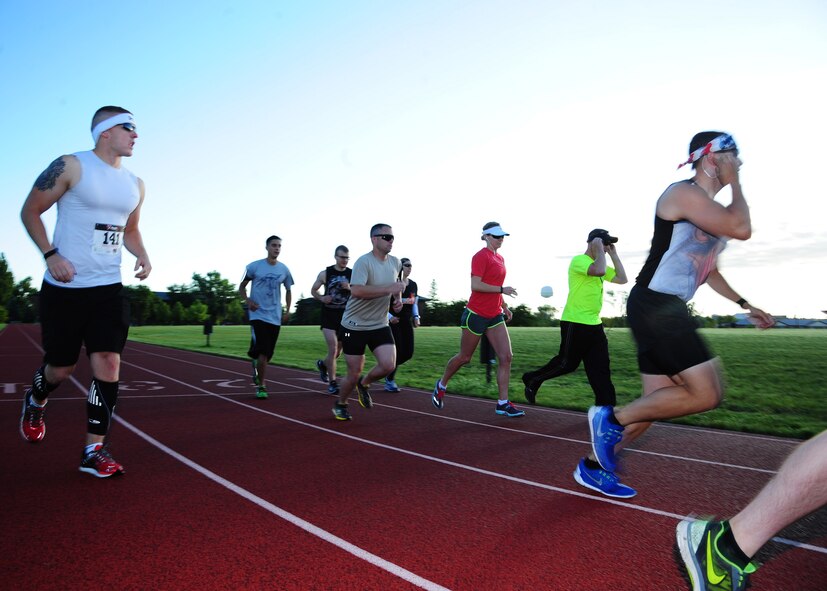 Airmen take off from the starting line of the Grand Forks Air Force Base 12-hour Relay July 24, 2015. Airmen competed as either a team or individually and collected pledges to raise money for the Wounded Airman Program.Teams were required to have at least one person running at all times during the event. (U.S. Air Force photo by Airman 1st Class Ryan Sparks/released)