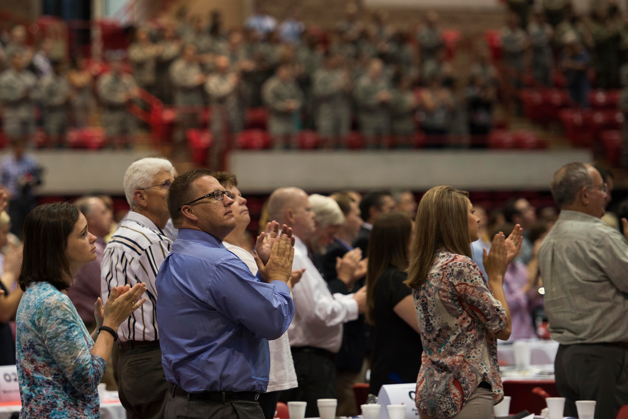 U.S. Air Force Airmen, in attendance with the Wichita Falls community, applaud Medal of Honor recipient retired U.S. Army Master Sgt. Leroy Petry, retired U.S. Army Sgt. 1st Class Dana Bowman and retired U.S. Army Staff Sgt. Shilo Harris after their speeches during the Wichita Falls Leadership Breakfast at the Kay Yeager Coliseum in Wichita Falls, Texas, July 24, 2015. Each of the speakers shared their stories of resiliency and courage with hopes to inspire people to overcome their own challenges. (U.S. Air Force photo by Senior Airman Kyle Gese/Released)
