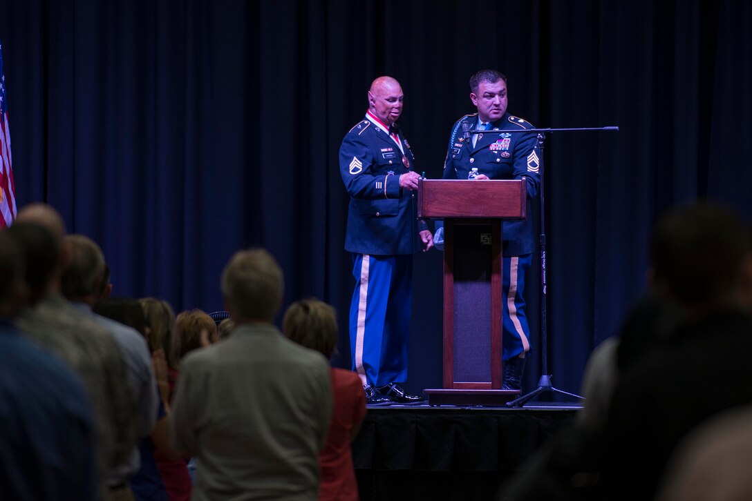 U.S. Air Force Airmen, in attendance with the Wichita Falls community, listen to Medal of Honor recipient retired U.S. Army Master Sgt. Leroy Petry and retired U.S. Army Staff Sgt. Shilo Harris as they share the stage during the Wichita Falls Leadership Breakfast at the Kay Yeager Coliseum in Wichita Falls, Texas, July 24, 2015. Petry and Harris used their experience and disabilities to inspire other wounded warriors to overcome their challenges. Petry lost his hand while tossing a live grenade to save his soldiers. Harris suffered severe burns and injuries from an explosion that mangled his Humvee, killing three of his partners. (U.S. Air Force photo by Senior Airman Kyle Gese/Released)
