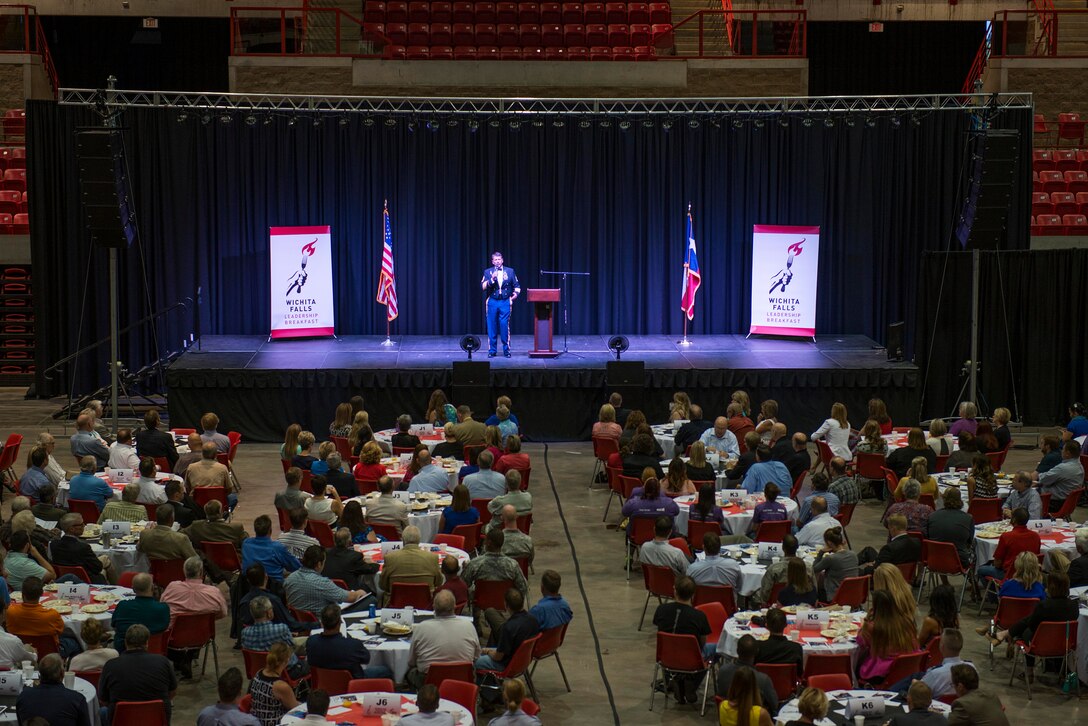 U.S. Air Force Airmen, in attendance with the Wichita Falls community, listen to retired U.S. Army Sgt. 1st Class Dana Bowman share his story of overcoming his challenges as a double amputee during the Wichita Falls Leadership Breakfast at the Kay Yeager Coliseum in Wichita Falls, Texas, July 24, 2015. Bowman suffered a critical accident while skydiving with the Army Golden Knights, colliding with his partner during their free fall. The accident left him a double amputee. Regardless, Bowman seized opportunities to participate in activities that would later lead him to reenlisting and skydiving again. (U.S. Air Force photo by Senior Airman Kyle Gese/Released)
