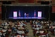 U.S. Air Force Airmen, in attendance with the Wichita Falls community, listen to retired U.S. Army Sgt. 1st Class Dana Bowman share his story of overcoming his challenges as a double amputee during the Wichita Falls Leadership Breakfast at the Kay Yeager Coliseum in Wichita Falls, Texas, July 24, 2015. Bowman suffered a critical accident while skydiving with the Army Golden Knights, colliding with his partner during their free fall. The accident left him a double amputee. Regardless, Bowman seized opportunities to participate in activities that would later lead him to reenlisting and skydiving again. (U.S. Air Force photo by Senior Airman Kyle Gese/Released)