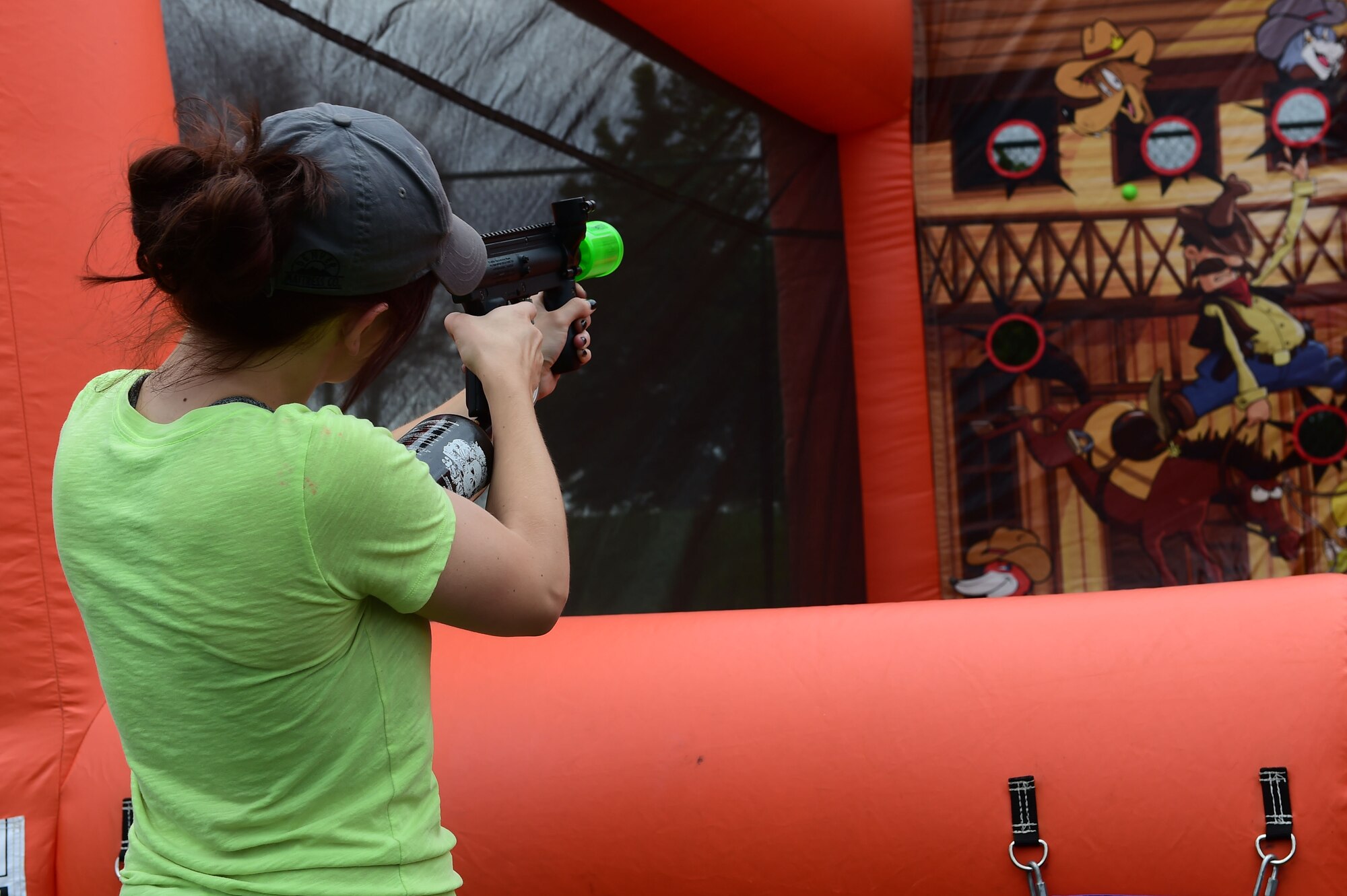 A girl takes aim at targets during FunFest July 24, 2015, at Buckley Air Force Base, Colo. FunFest is an annual base-wide event that includes family- friendly games and activities, community involvement and local business sponsors. (U.S. Air Force photo by Airman 1st Class Luke W. Nowakowski/Released)