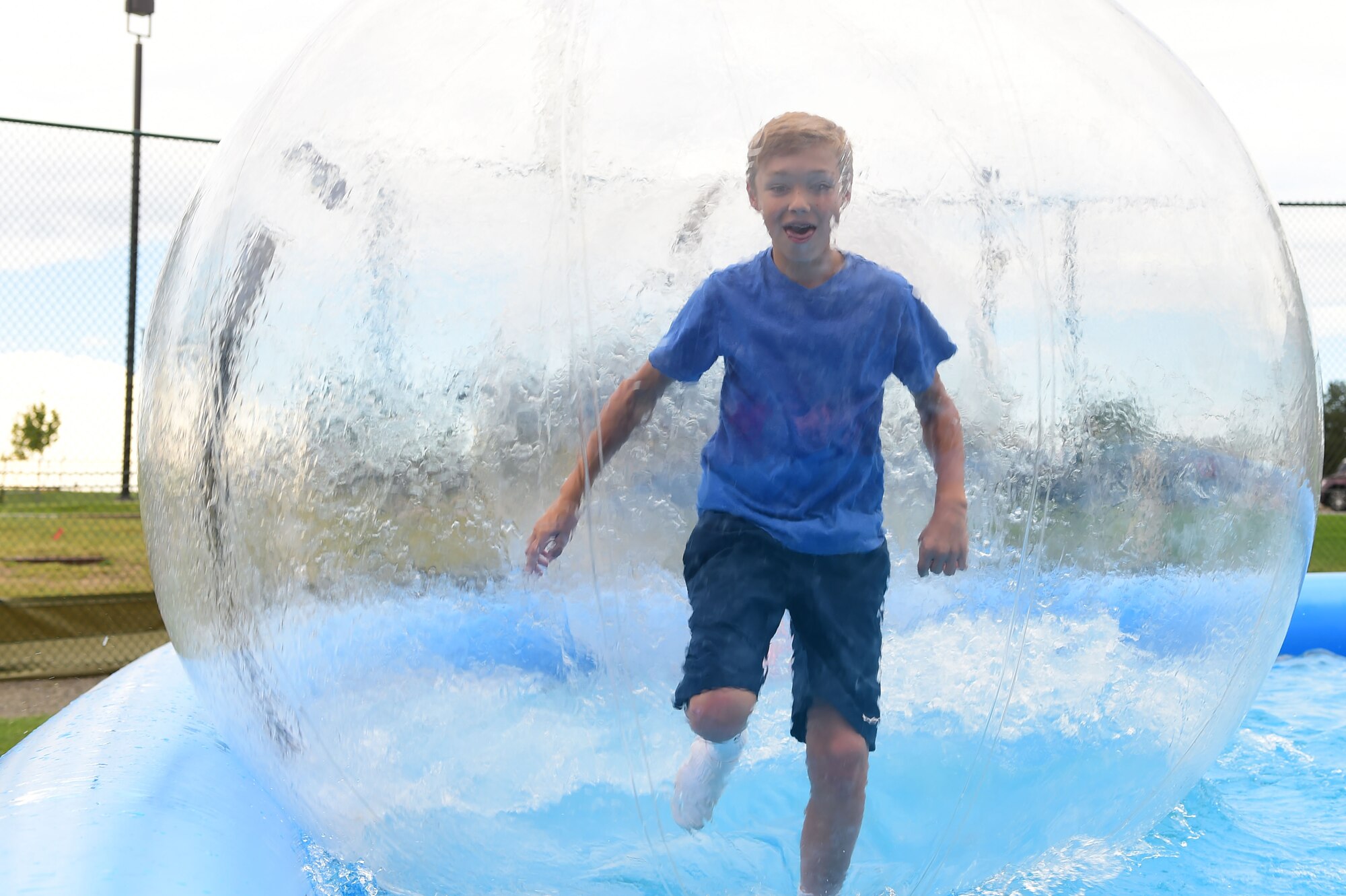 A boy “runs on water” during FunFest July 24, 2015, at Buckley Air Force Base, Colo. FunFest is an annual base-wide event that includes family-friendly games and activities, community involvement and local business sponsors. (U.S. Air Force photo by Airman 1st Class Luke W. Nowakowski/Released)
