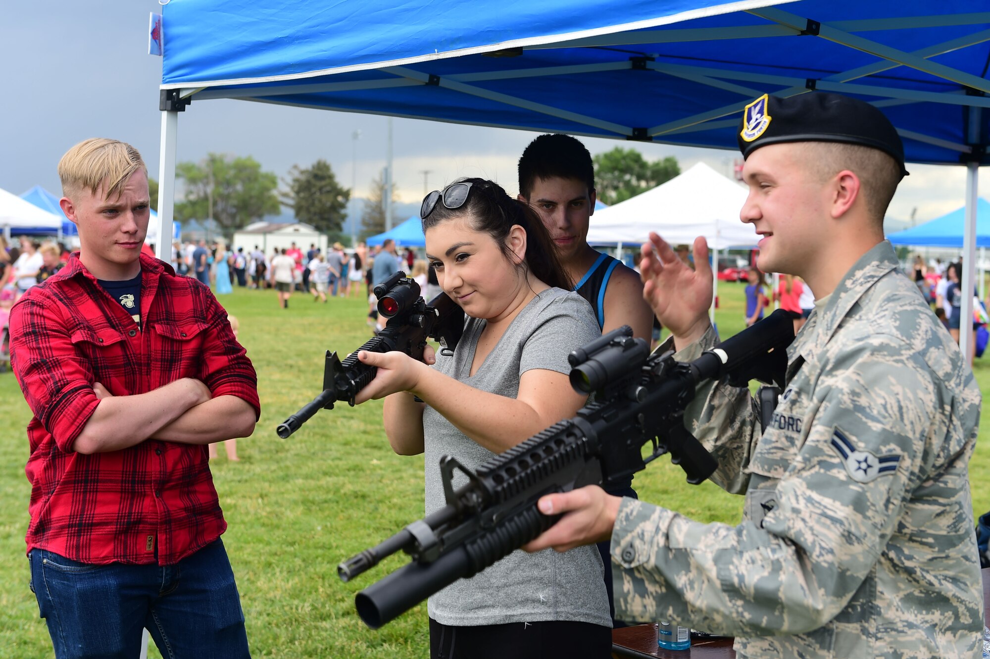 A member of the 460th Security Forces Squadron demonstrates how to use a weapon during FunFest July 24, 2015, at Buckley Air Force Base, Colo. FunFest is an annual base-wide event that includes family-friendly games and activities, community involvement and local business sponsors. (U.S. Air Force photo by Airman 1st Class Luke W. Nowakowski/Released)