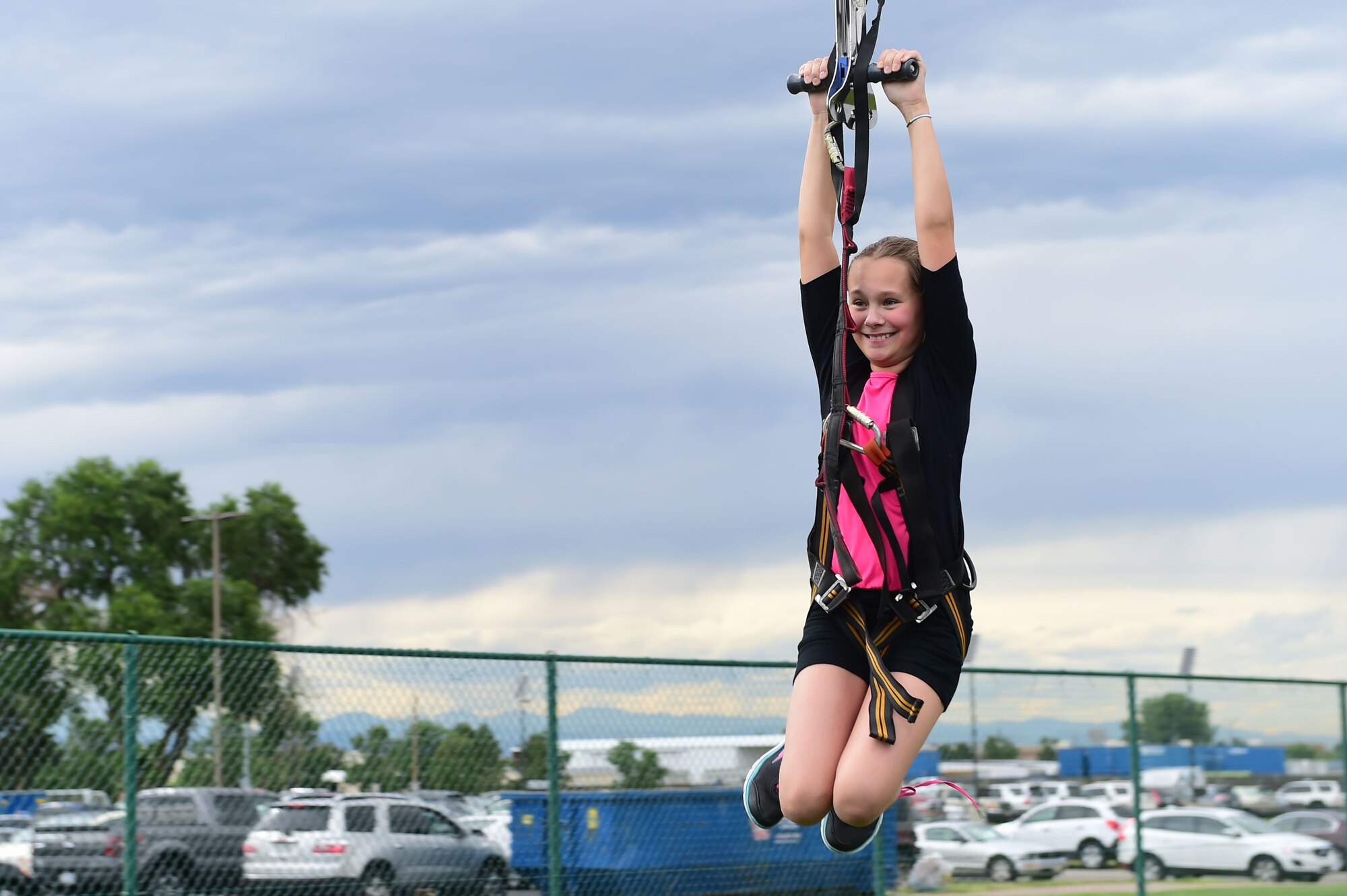 A child from Team Buckley glides down a zip line during FunFest July 24, 2015, at Buckley Air Force Base, Colo. FunFest is an annual base-wide event that includes family-friendly games and activities, community involvement and local business sponsors. (U.S. Air Force photo by Airman 1st Class Luke W. Nowakowski/Released)