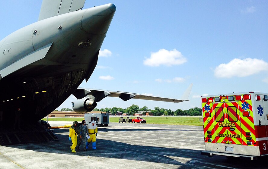 Omaha Fire and Rescue Department personnel in personal protective equipment transfer a simulated patient with a highly contagious disease to an ambulance July 23 as part of exercise PATRIOT 15. Three patients with simulated illnesses were airlifted from Volk Field, Wisconsin to Offutt Air Force Base, Nebraska for transfer to the University of Nebraska Medical Center’s Biocontainment Unit. The annual exercise, sponsored by the National Guard Bureau, is used to practice domestic operations within the United States. (U.S. Air Force photo by Delanie Stafford/Released)