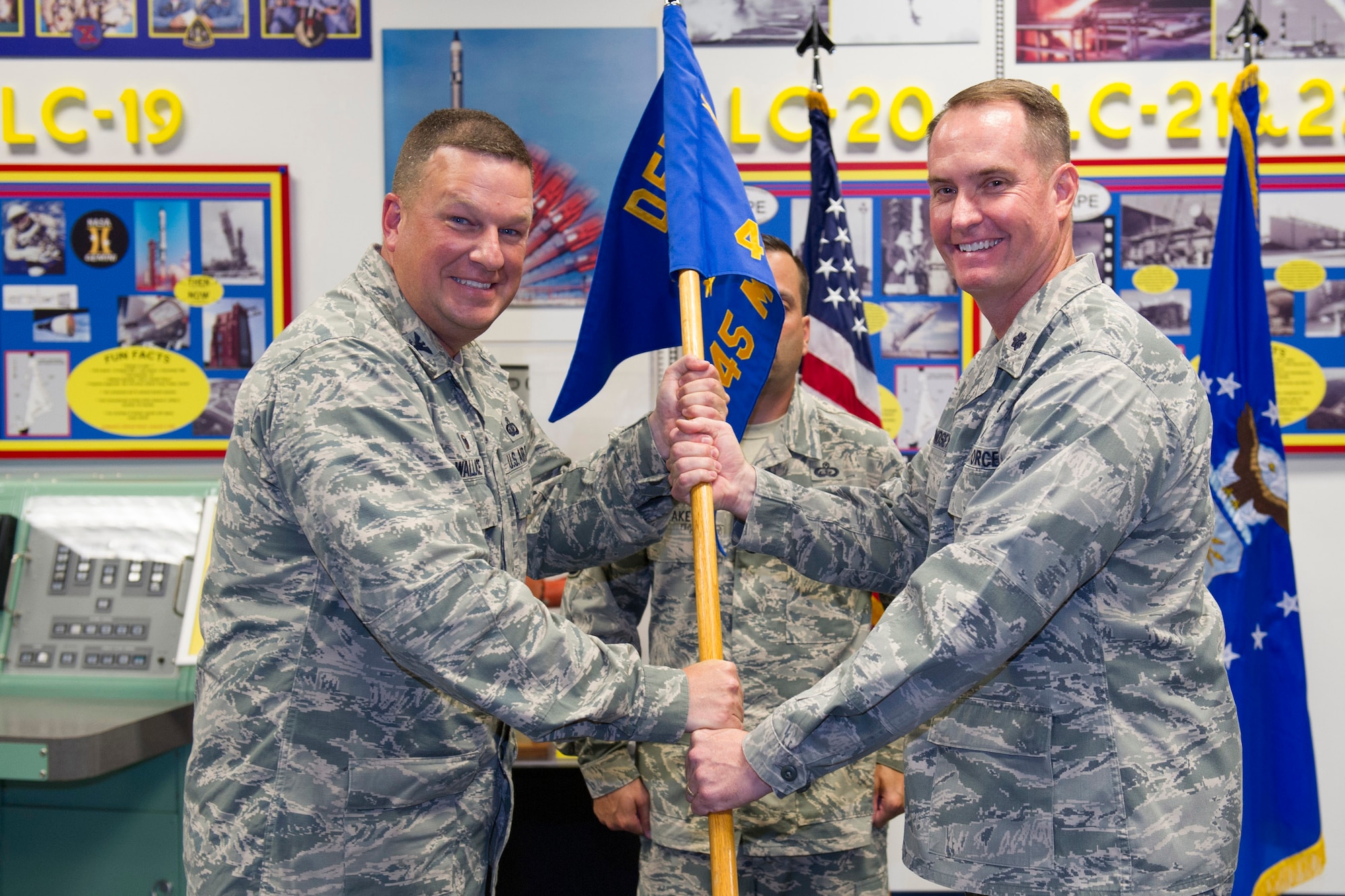 Col. Matthew Wallace, 45th Mission Support Group commander, left, presents Lt. Col. Gregory Lindsey, 45th MSG Detachment 1 commander, with the 45th MSG Det.1 guidon during a change of command ceremony, July 20, 2015, at Cape Canaveral Air Force Station, Fla. Changes of command are a military tradition representing the transfer of responsibilities from the presiding officials to the upcoming official. (U.S. Air Force photo/Matthew Jurgens) (Released) 
