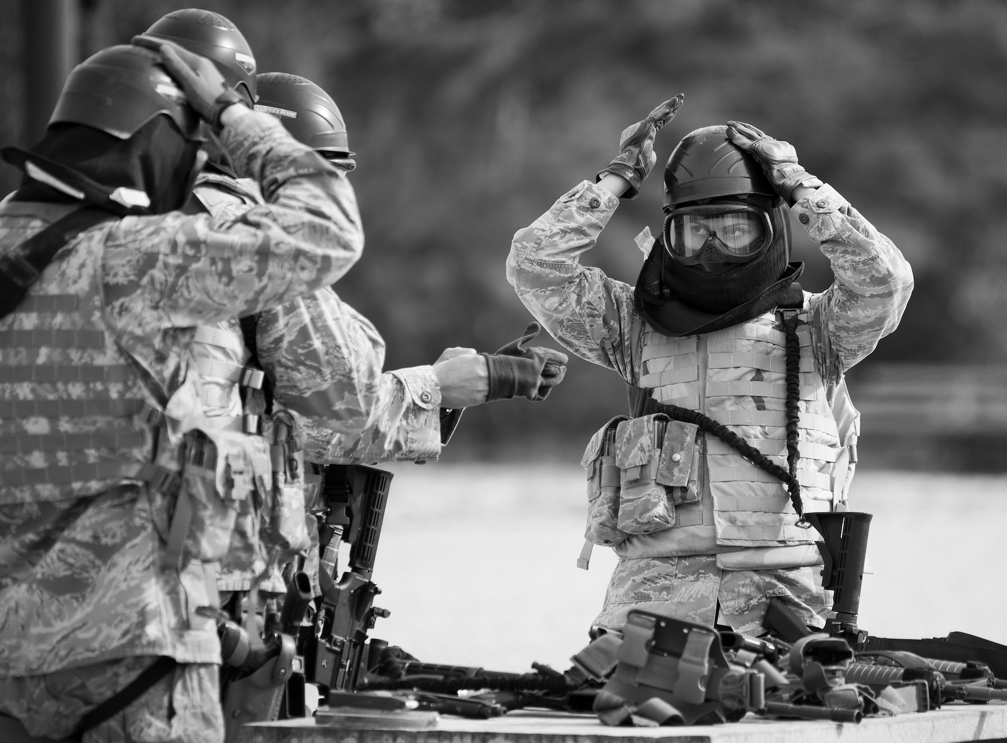 A 96th Security Forces Squadron Airman secures his helmet prior to a shoot, move and communicate drill at Eglin Air Force Base, Fla.  The mandatory training requirement is in addition to annual weapons qualification training.  The exercise consists of Airmen firing simmunition ammo while advancing toward, away from and to the side of a target.  This is followed by a building sweep and clear drill.  The Defenders perform the highly kinetic training at Eglin’s Base Tango range.  The range was previously used for security forces pre-deployment training.  (U.S. Air Force photo/Samuel King Jr.)