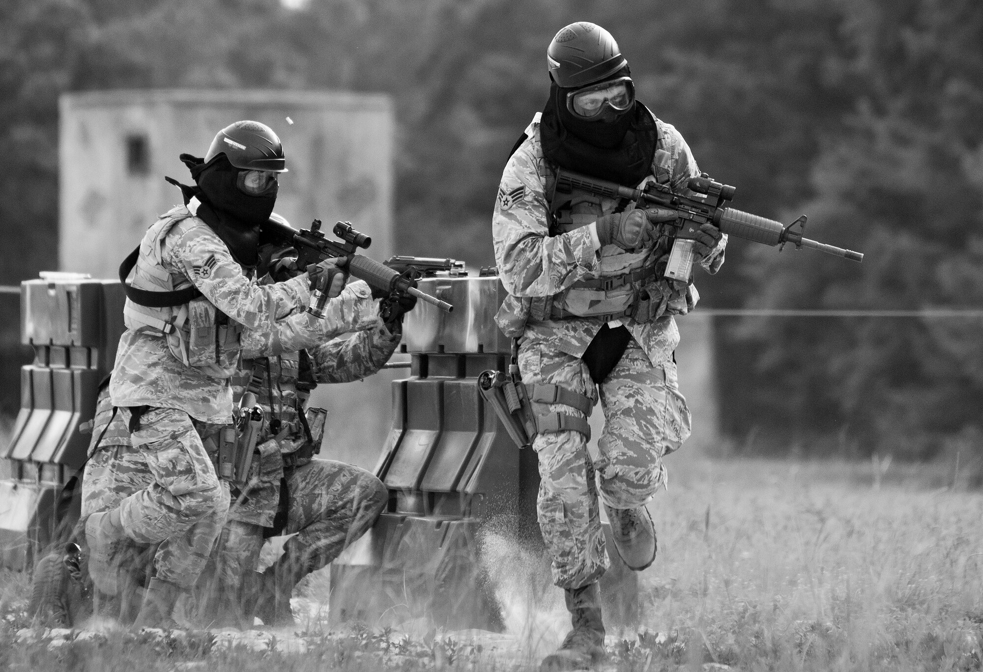 A team of 96th Security Forces Squadron Airmen perform a side-advancing movement during a shoot, move and communicate drill in June at Eglin Air Force Base, Fla.  The mandatory training requirement is in addition to annual weapons qualification training.  The exercise consists of Airmen firing simmunition ammo while advancing toward, away from and to the side of a target.  This is followed by a building sweep and clear drill.  The Defenders perform the highly kinetic training at Eglin’s Base Tango range.  The range was previously used for security forces pre-deployment training.  (U.S. Air Force photo/Samuel King Jr.)