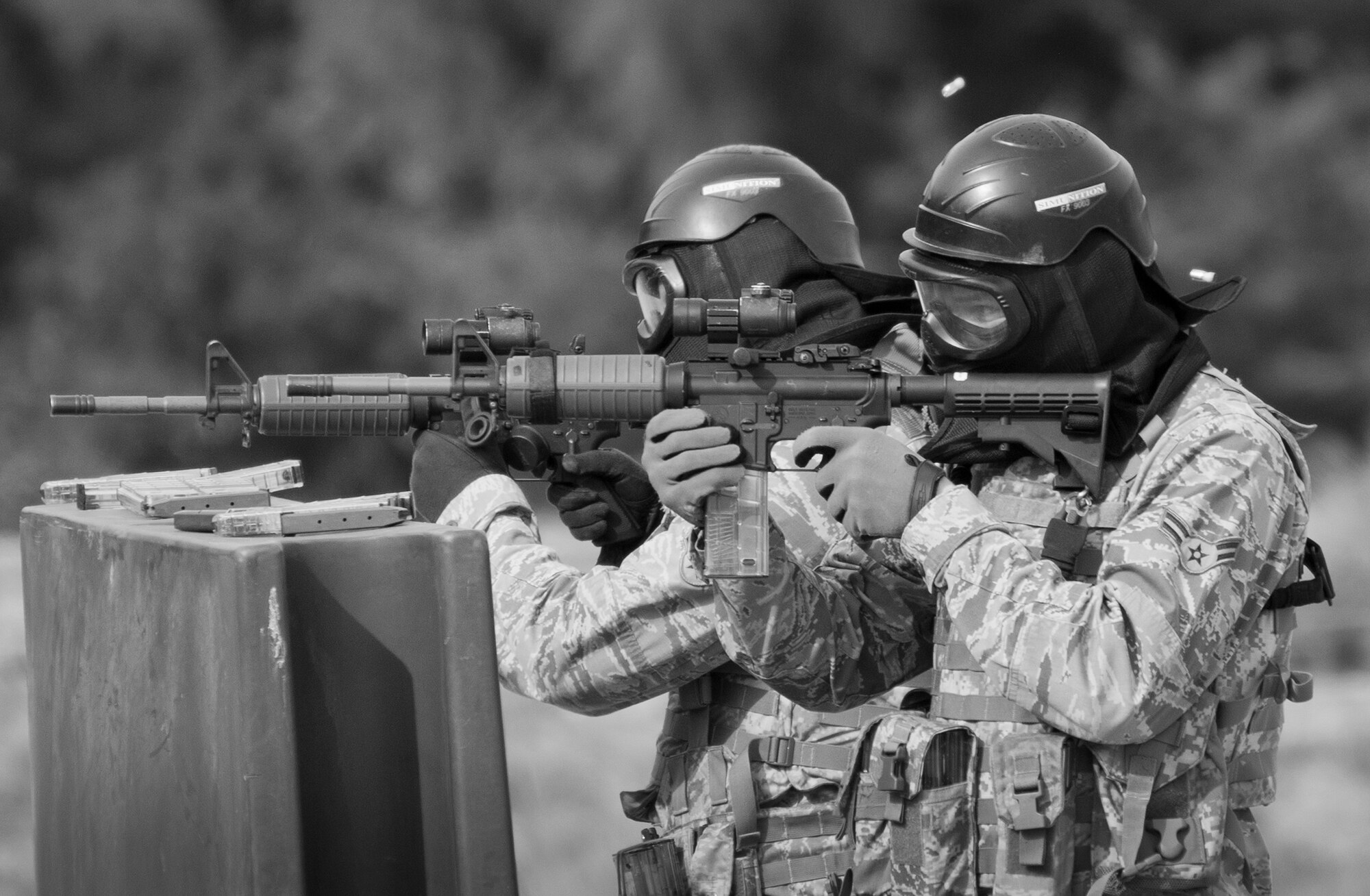 Simmunition rounds pop out of 96th Security Forces Squadron Airmen’s M-4 rifles as they fire downrange during a shoot, move and communicate drill in June at Eglin Air Force Base, Fla.  The mandatory training requirement is in addition to annual weapons qualification training.  The exercise consists of Airmen firing simmunition ammo while advancing toward, away from and to the side of a target.  This is followed by a building sweep and clear drill.  The Defenders perform the highly kinetic training at Eglin’s Base Tango range.  The range was previously used for security forces pre-deployment training.  (U.S. Air Force photo/Samuel King Jr.)