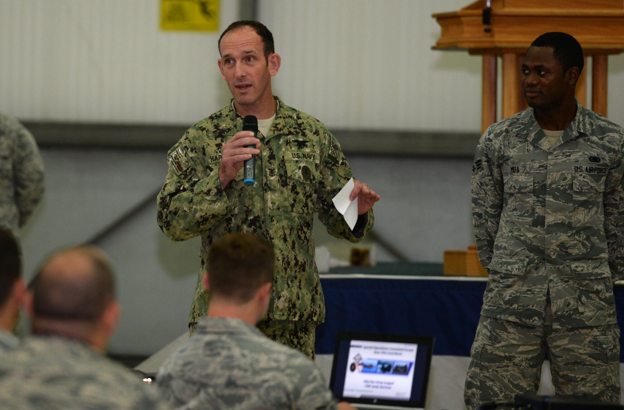 From left, U.S. Navy Command Master Chief Petty Officer Andrew Harrison, U.S. Special Operations Command - Europe senior enlisted leader, asks Airmen quiz questions about themselves, their chain of command and home station July 23, 2015, on RAF Mildenhall, England. Harrison then used charts to explain SOCEUR chain of command and the challenges the military faces today and how the U.S. military is making European militaries stronger. (U.S. Air Force photo by Gina Randall/Released)