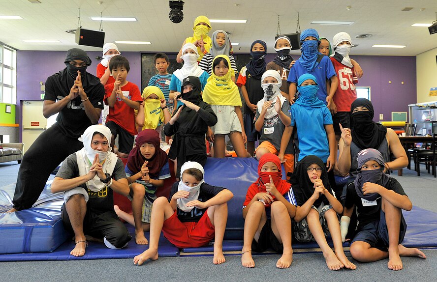 Japanese and American children pose with ninja masks for a group photo at the Youth Center during their visit on Kadena Air Base, Japan, July 23, 2015. The visit gave American and Japanese children an opportunity to exchange culture by playing games and eating lunch together. (U.S. Air Force photo by Naoto Anazawa)