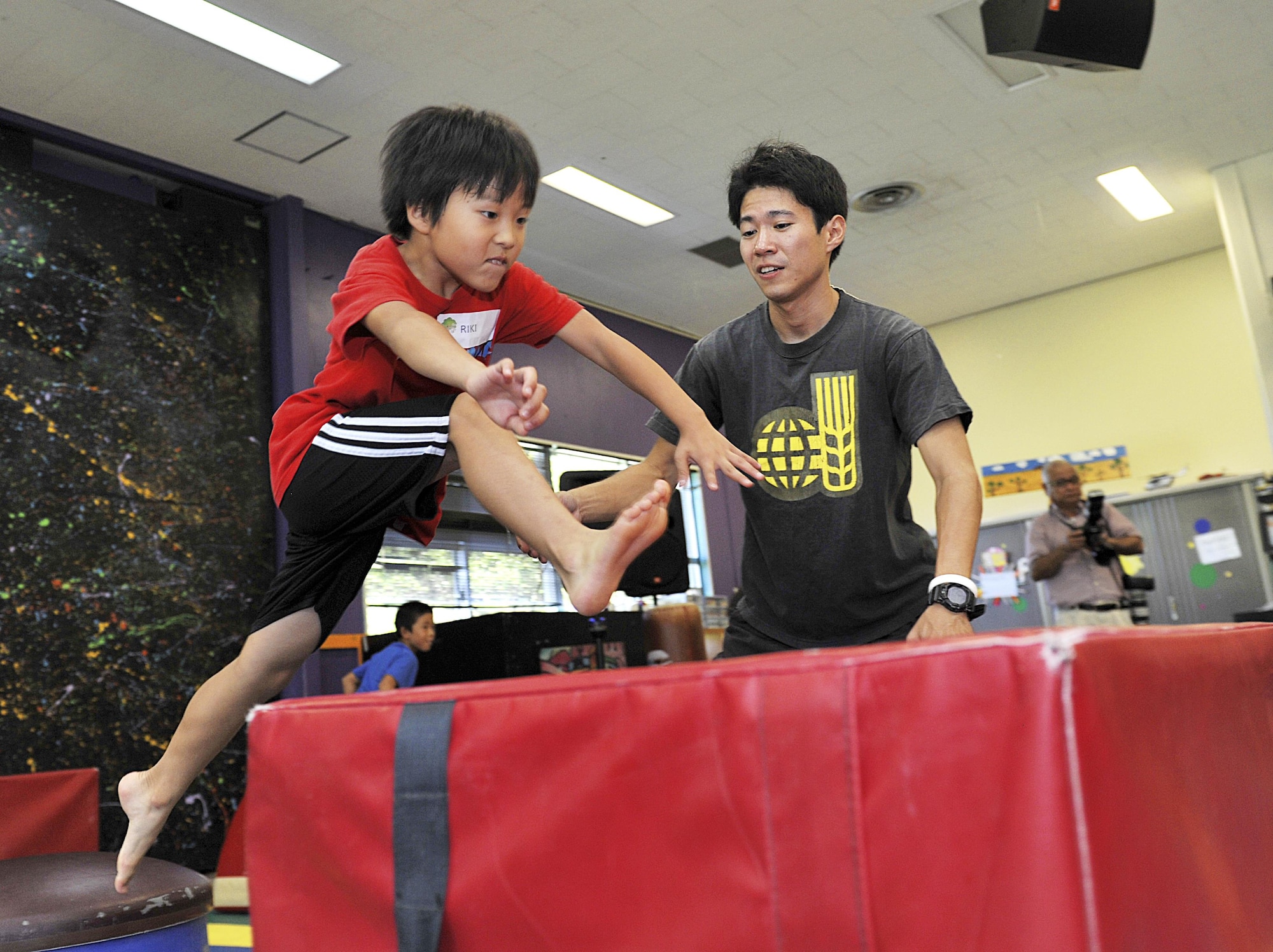 Riki Kaneko (9) from Chatan Elementary School jumps a ninja obstacle block at the Youth Center during a visit on Kadena Air Base, Japan, July 23, 2015. A total of 14 children from Chatan Town elementary schools participated in the culture exchange program. During their visit, the children ate lunch with and played with American children around their own ages in an effort to learn more about American culture and language. (U.S. Air Force photo by Naoto Anazawa)