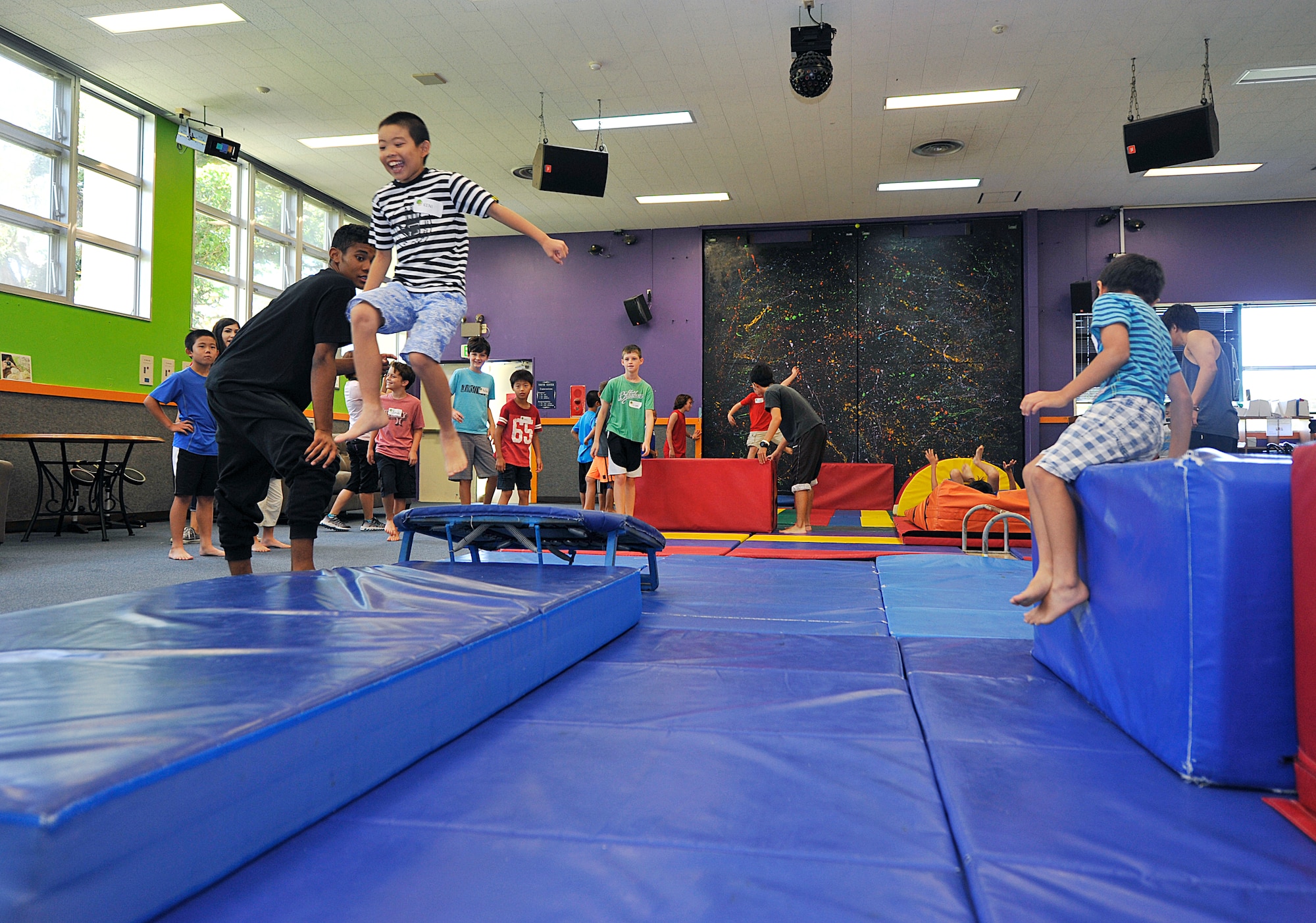 Japanese and American children play in a ninja obstacle exercise at the Youth Center during a visit on Kadena Air Base, Japan, July 23, 2015. During the visit, Japanese and American children played ping pong, and other games, and ate American style lunch together. (U.S. Air Force photo by Naoto Anazawa)