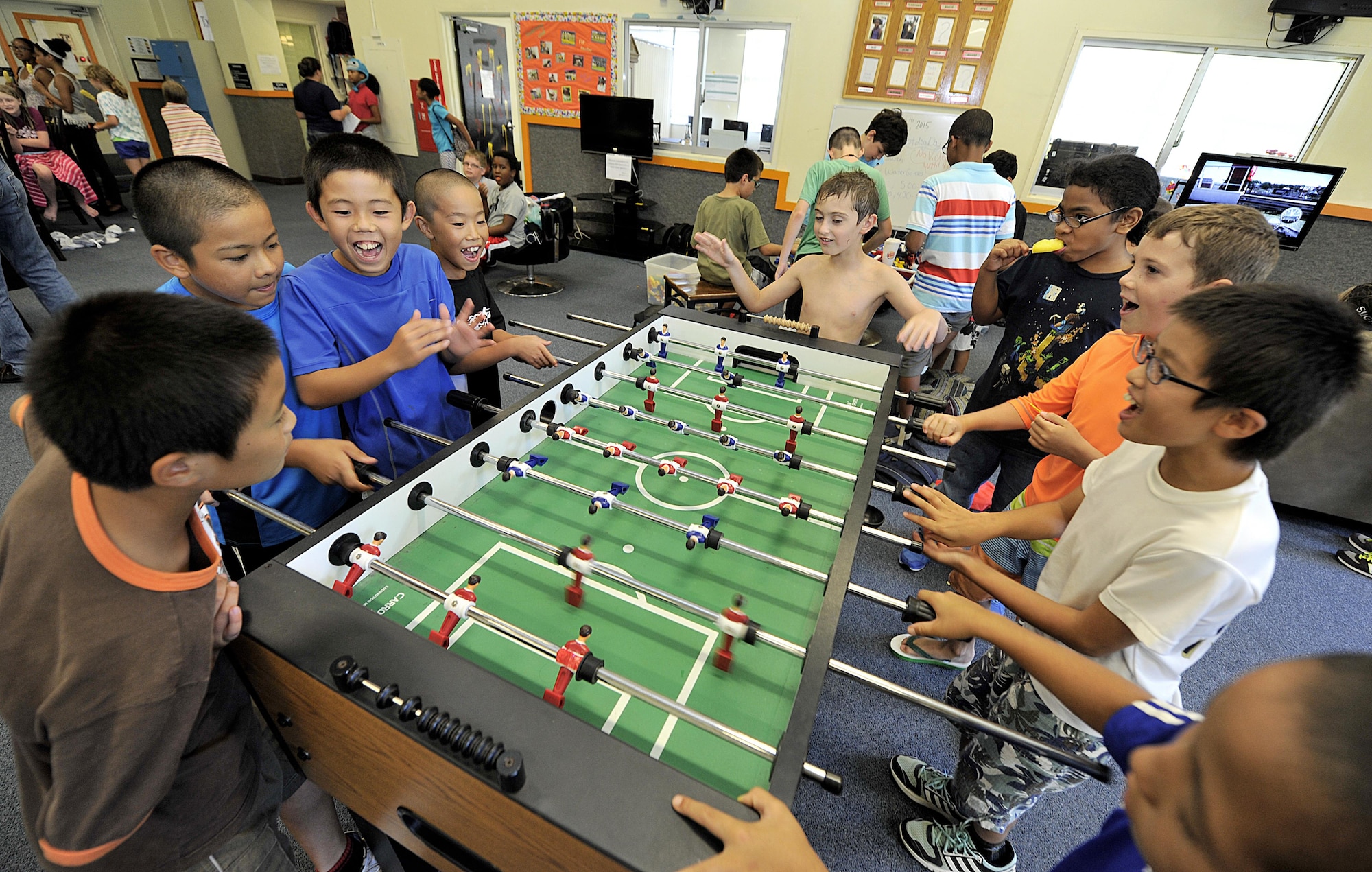 Japanese children from Chatan Town elementary schools play football with American children at the Youth Center during a visit on Kadena Air Base, Japan, July 23, 2015. The visit allowed American and Japanese children to exchange culture by playing games and eating lunch together. (U.S. Air Force photo by Naoto Anazawa)