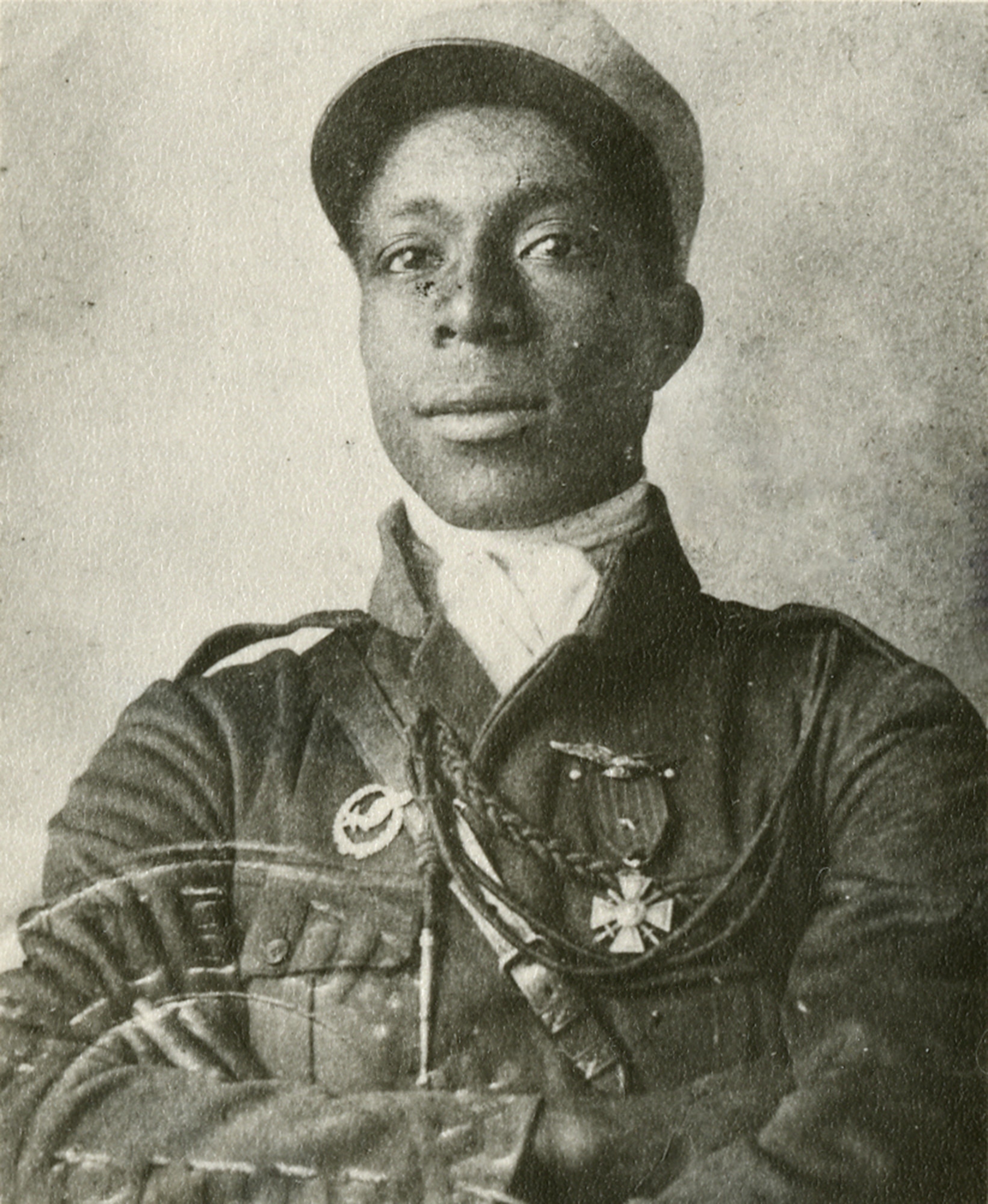 Photograph of Eugene Jacques Bullard during his flight training. The insignia on his right chest is his student pilot insignia, and the Croix de Guerre with Star he received for valor during the Battle of Verdun on his left. Just visible over the Croix de Guerre on the left are unofficial wings worn by many French pilots. (U.S. Air Force photo)