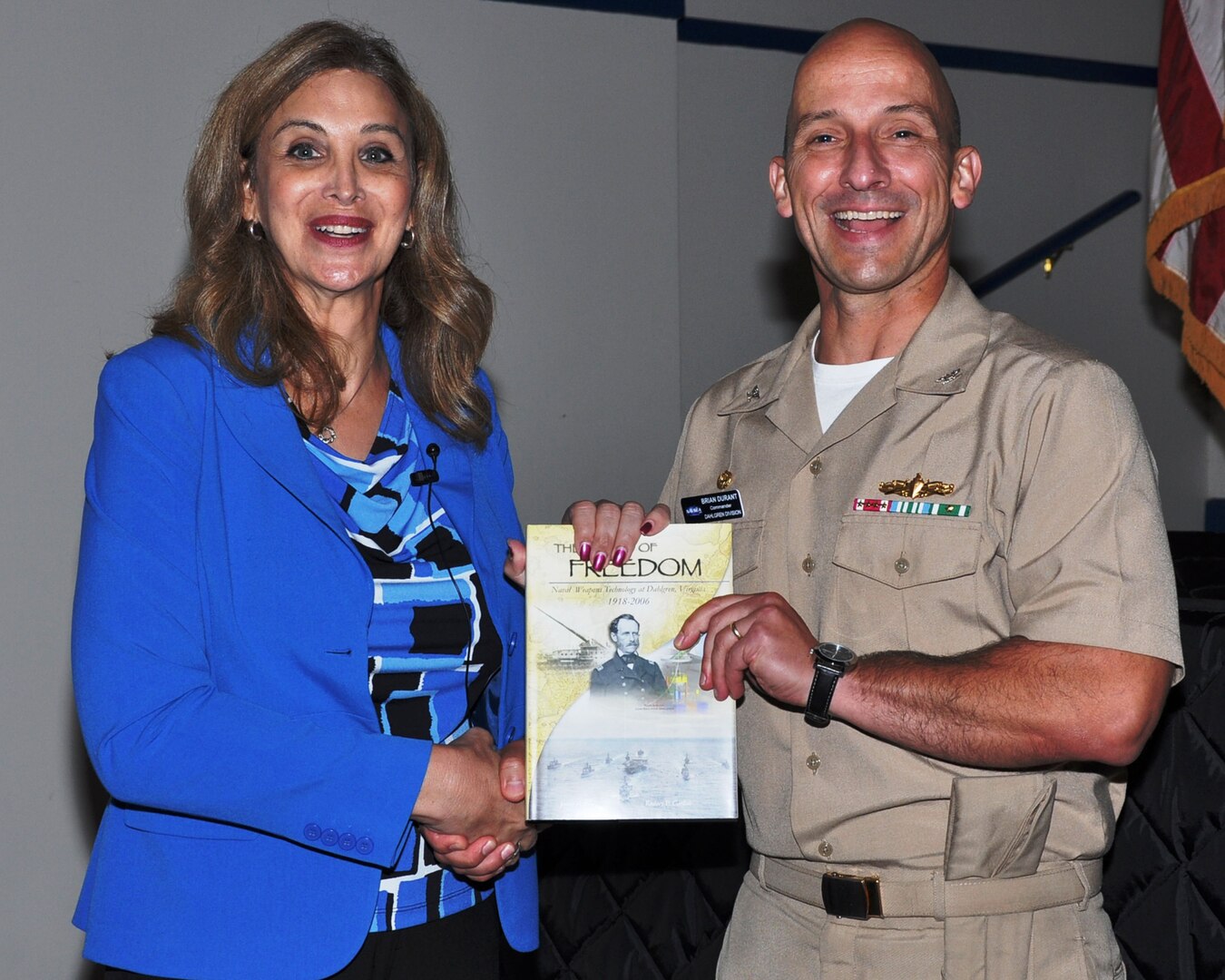 Capt. Brian Durant, right, commander of the Naval Surface Warfare Center Dahlgren Division (NSWCDD), presents "The Sound of Freedom" to Amanda Simpson, left, executive director of the Army Office of Energy Initiatives, after her presentation at the LGBT Pride Month Observance at Naval Support Facility (NSF) Dahlgren on July 24. 
