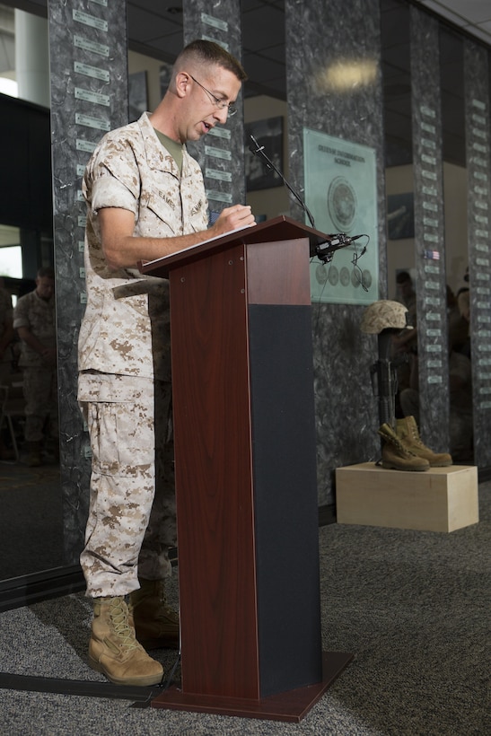 U.S. Marine Corps Capt. Caleb Eames, Public Affairs Officer for Okinawa, Japan, gives the opening benediction during a memorial service and induction ceremony in the Hall of Heroes at the Defense Information School on Fort George G. Meade, Md., July 27, 2015. The ceremony was in honor of U.S. Marine Corps Cpl. Sara A. Medina and Lance Cpl. Jacob A. Hug, combat photographers who were killed during earthquake relief operations in Nepal, May 12, 2015. (DoD photo by Shane Keller/Released)