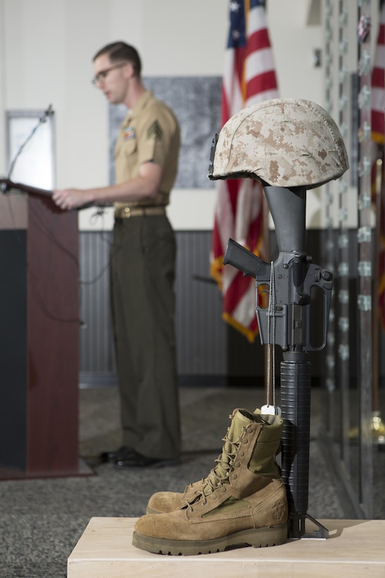 U.S. Marine Corps Sgt. Matthew Troyer, Basic Still Photography instructor at the Defense Information School, explains the history of the Hall of Heroes during a memorial service and induction ceremony at DINFOS on Fort George G. Meade, Md., July 27, 2015. The ceremony was in honor of U.S. Marine Corps Cpl. Sara A. Medina and Lance Cpl. Jacob A. Hug, combat photographers who were killed during earthquake relief operations in Nepal, May 12, 2015. (DoD photo by Shane Keller/Released)