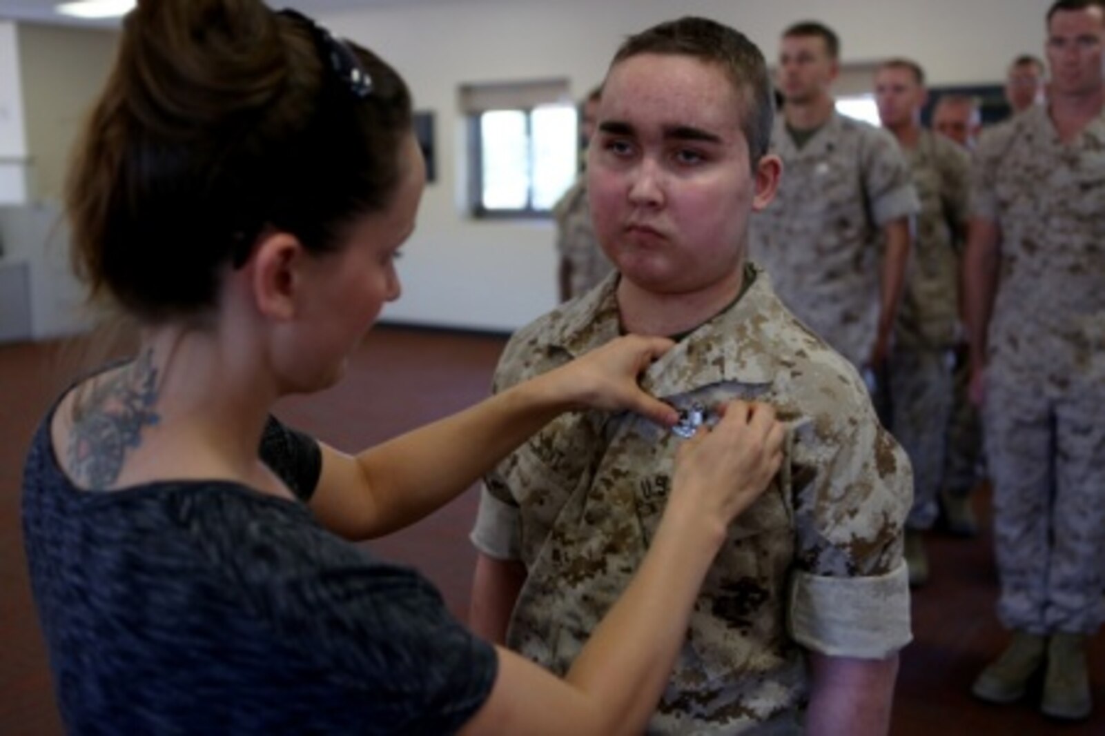 James Gallant, a young man diagnosed with brain cancer, is pinned with an Explosive Ordnance Disposal technician badge by his mother Sarah Silverstein, before Marines of 1st EOD Company, 1st Marine Logistics Group, aboard Camp Pendleton, Calif., July 25, 2015. Collaborating with the Make-A-Wish Foundation, 1st EOD helped James experience what being an EOD technician is like by giving him a tour through their library of ordnance and EOD tools, teaching him to operate the TALON bomb disposing robot and presenting him with his own desert utilities and EOD badge.