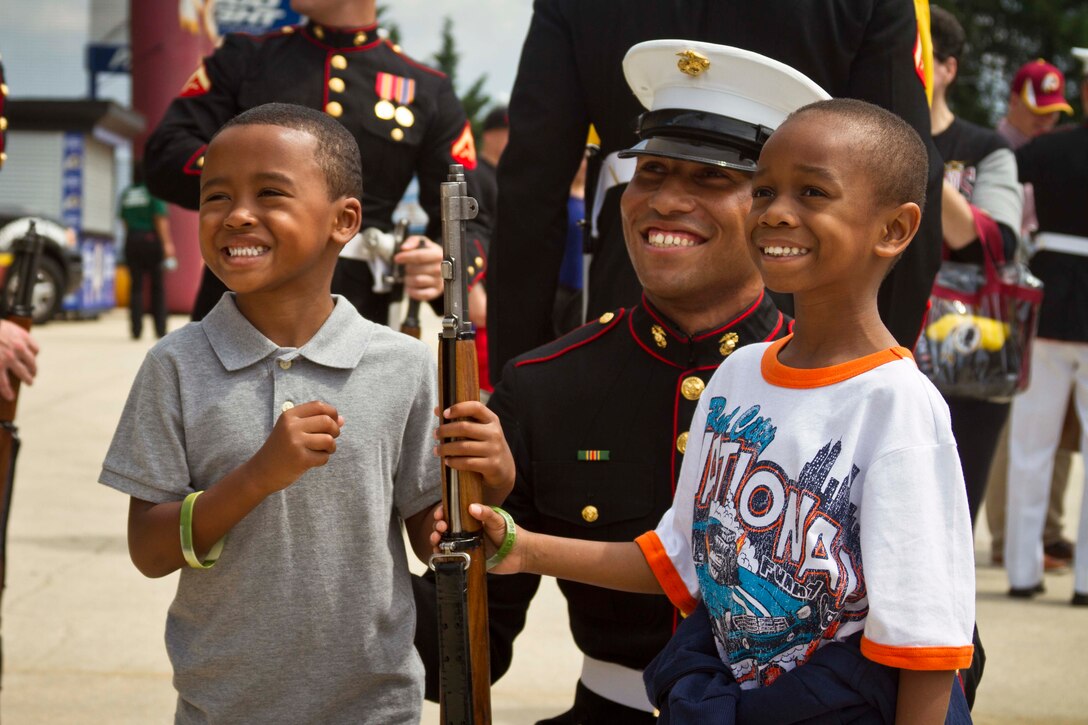 U.S. Marine Corps Lance Cpl. Justin Searcy, a member of the United States Marine Corps Silent Drill Platoon and a native of Nashville, Tennessee, poses for a picture with the crowd at FedEx Field during the Washington Redskins’ Military Appreciation Day in Hyattsville, Maryland, July 11, 2015. The Silent Drill Platoon travels across the country and the world showcasing close-order drill and the precision for which the Marine Corps is known. (U.S. Marine Corps photo by Sgt. Bryan Nygaard/Released)