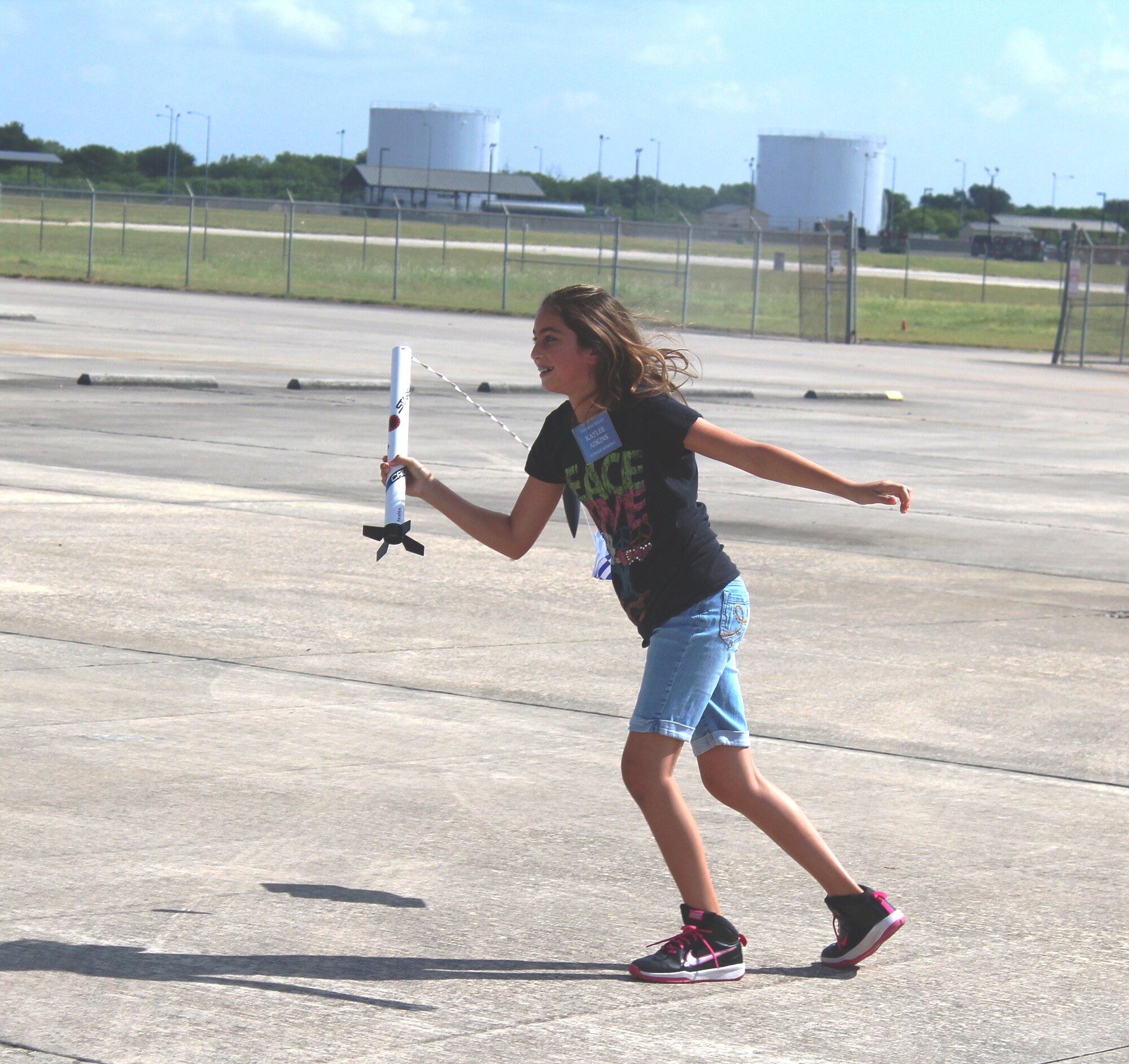 Kayla Adkins, daughter of Master Sgt. Helen Adkins, a training and logistics readiness manager at the 149th Fighter Training Wing, catches her model rocket after a successful launch on the final morning of her week-long class at DoD STARBASE-Kellyat Joint Base San Antonio-Lackland, Texas on July 17, 2015. Kayla, along with 19 other students, successfully launched her rocket later on that morning. (U.S. Air Force photo/Tech. Sgt. Carlos J. Trevino) 
