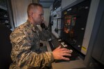 U.S. Air Force Senior Airman Jonathan R. Smail a transmission technician from the 233d Space Communications Squadron, Colorado Air National Guard, monitors computer systems in a mobile satellite trailer at Greeley Air National Guard Station, Greeley Colorado, on June 7, 2015. He was named Outstanding Airman of 2015.