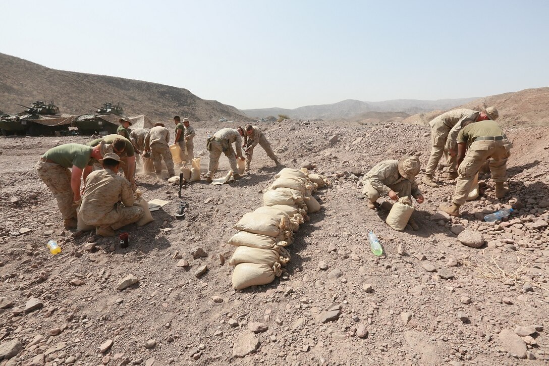 ARTA BEACH, Djibouti (July 22, 2015) U.S. Marines with the 15th Marine Expeditionary Unit fill sand bags to construct an entry control point at a cantonment area ashore during sustainment training. Elements of the 15th Marine Expeditionary Unit are ashore in Djibouti for sustainment training to maintain and enhance the skills they developed during their pre-deployment training period.  The 15th MEU is currently deployed in support of maritime security operations and theater security cooperation efforts in the U.S. 5th and 6th Fleet areas of operation. (U.S. Marine Corps photo by Sgt. Steve H. Lopez/Released)