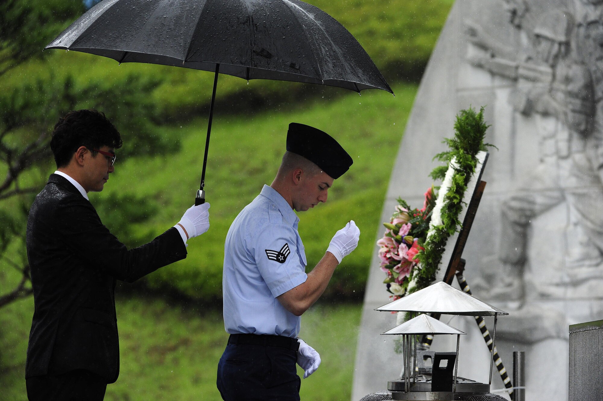 U.S. Air Force Senior Airman Drew Hagen, 8th Maintenance Group, Kunsan Air Base, Republic of Korea, transfers incense to an urn with ceremonial gloves during the official proceedings of a Korean Armistice Agreement anniversary ceremony at Imsil National Cemetery, ROK, July 24, 2015. The incense was burned in the accompanying urn in remembrance of the lives lost and the sacrifices made during the Korean War. (U.S. Air Force photo by Staff Sgt. Nick Wilson/Released)
