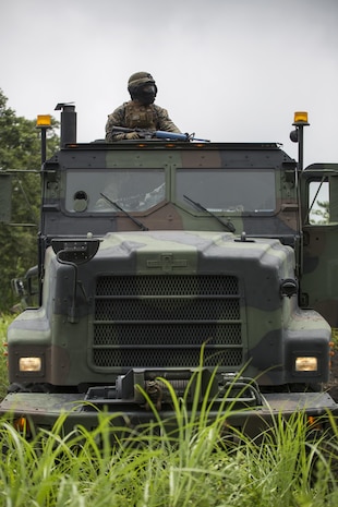 Sgt. Paul D. Johnis, a ground radio repairman with Combat Logistics Company 36, posts security in the gunner’s seat of an AMK-27 medium tactical vehicle during Exercise Dragon Fire 2015 at Combined Arms Training Center Camp Fuji, Japan, July 24. During the convoy and recovery operation portion of this exercise, Marines and Sailors learned to post 360 degree security, foot patrolling and the immediate action for responding to enemy fire. Allowing service members to practice real life scenarios aided in combat mindset development to prepare them for the mental and physical stress of a combat zone. CLC-36 conducts this exercise annually to make their service members a little more combat ready by recapping the basic skills they learn in boot camp or Marine combat training.