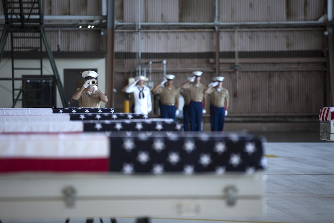 A bugler with the U.S. Marine Corps Forces, Pacific Band plays Taps during a dignified transfer ceremony, July 26, 2015. The remains of 36 Marines recovered from the Battle of Tarawa were returned to the U.S. for identification, return to their families and burial with full military honors. (U.S. Marine Corps photo by Cpl. Erik Estrada)