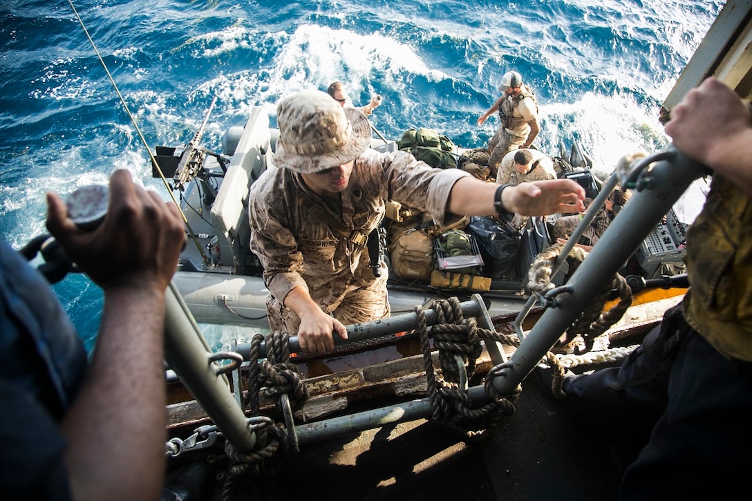 U.S. Marine Sgt. Alexander Hoodwin climbs aboard the amphibious assault ship USS Essex from a rigid hull inflatable boat on the Indian Ocean July 27, 2015. Hoodwin is a radio operator with the 15th Marine Expeditionary Unit. Elements of the 15th MEU, based out of Camp Pendleton, California, and embarked aboard the Essex, are conducting naval operations in the 6th Fleet areas of operation in support of U.S. national security interests in Europe and Africa.