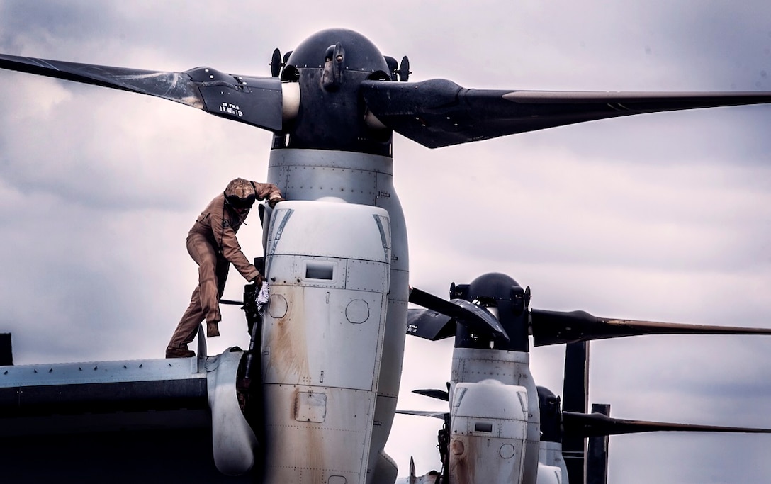 A U.S. Marine with the “Greyhawks” of Marine Medium Tiltrotor Squadron 161 (Reinforced), 15th Marine Expeditionary Unit, wipes down an MV-22B Osprey after takeoff and landing drills at Jomo Kenyatta International Airport july 23, 2015. The Marines are in Kenya to support President Barrack Obama’s visit. Elements of the 15th MEU, based out of Camp Pendleton, California, and embarked aboard the Essex, are conducting naval operations in the 6th Fleet areas of operation in support of U.S. national security interests in Europe and Africa. 