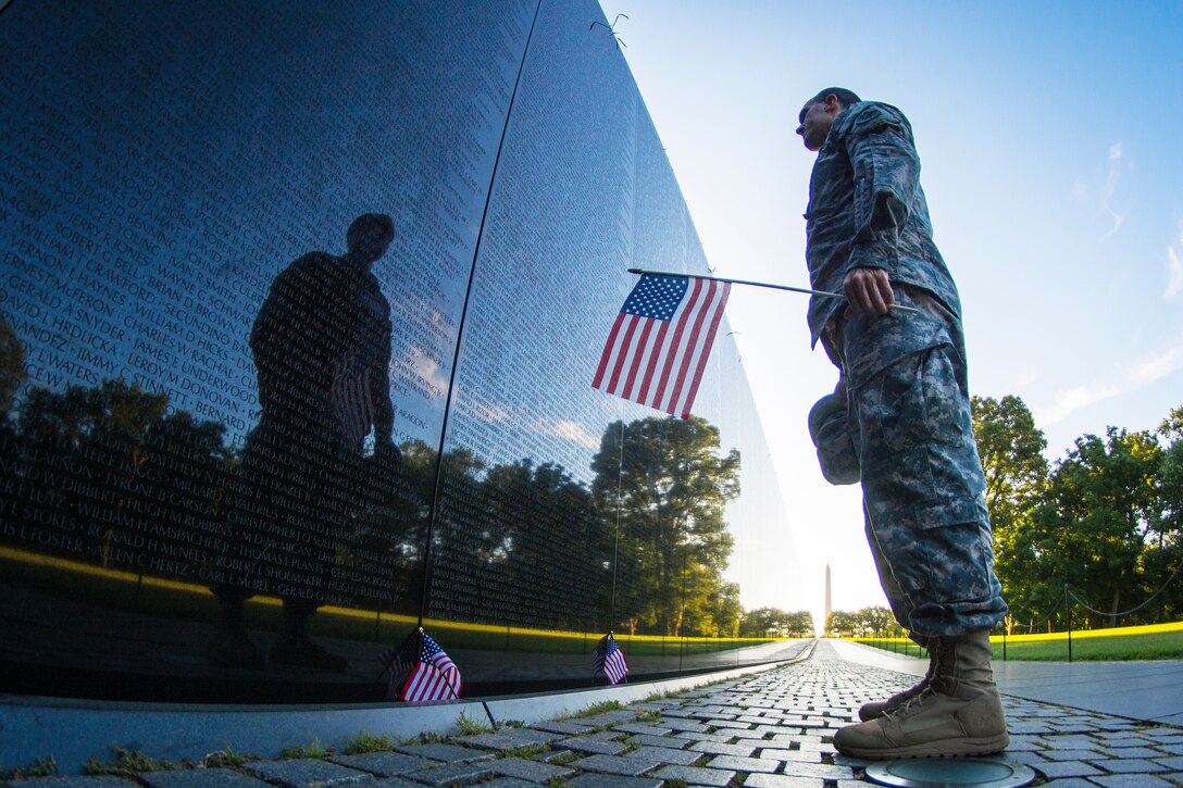 A soldier reads some of the 58,272 names etched into the Vietnam Veterans Memorial in Washington, D.C., July 22, 2015. The soldier is a member of the Army Reserve. Army photo by Sgt. Ken Scar