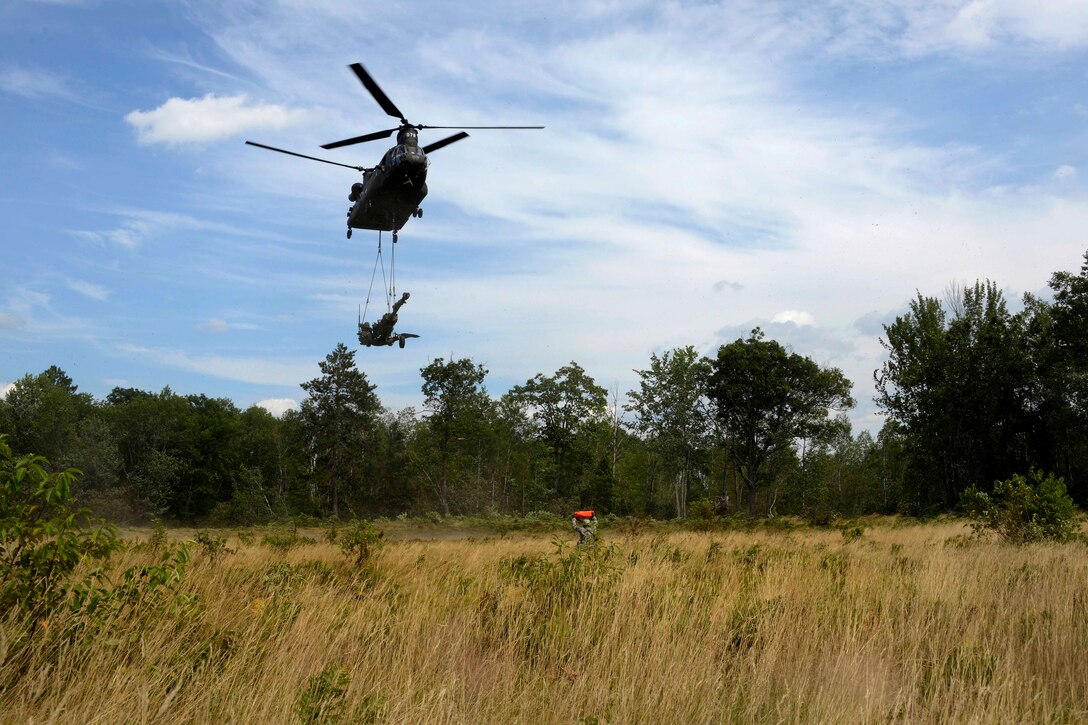 A Michigan Army National Guardsman guides a CH-47 Chinook helicopter ...