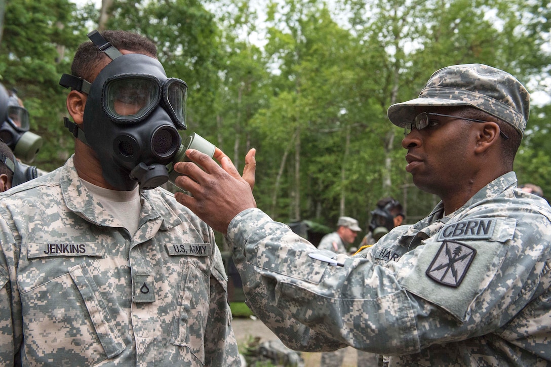 Army Staff Sgt. Dwight Harris, right, checks that Army Pfc. Nsilo Q. Jenkins' M40 field protective mask is functioning properly during chemical, biological, radiological and nuclear sustainment training on Joint Base Elmendorf-Richardson, Alaska, July 16, 2015. Harris, a CBRN specialist, and Jenkins are assigned to Company C, 307th Expeditionary Signal Battalion.