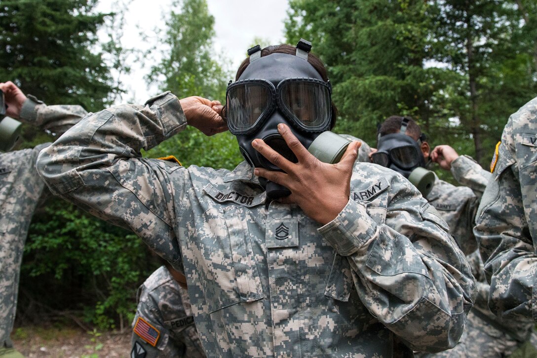 Army Sgt. 1st Class Anastassia C. Doctor applies an M40 field protective mask while conducting chemical, biological, radiological and nuclear sustainment training on Joint Base Elmendorf-Richardson, Alaska, July 16, 2015. Doctor is assigned to Company C, 307th Expeditionary Signal Battalion.