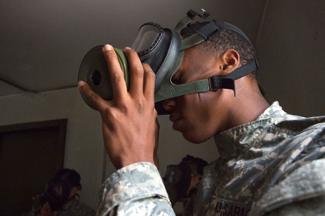 A soldier breaks the seal to an M40 field protective mask during chemical, biological, radiological and nuclear sustainment training on Joint Base Elmendorf-Richardson, Alaska, July 16, 2015.