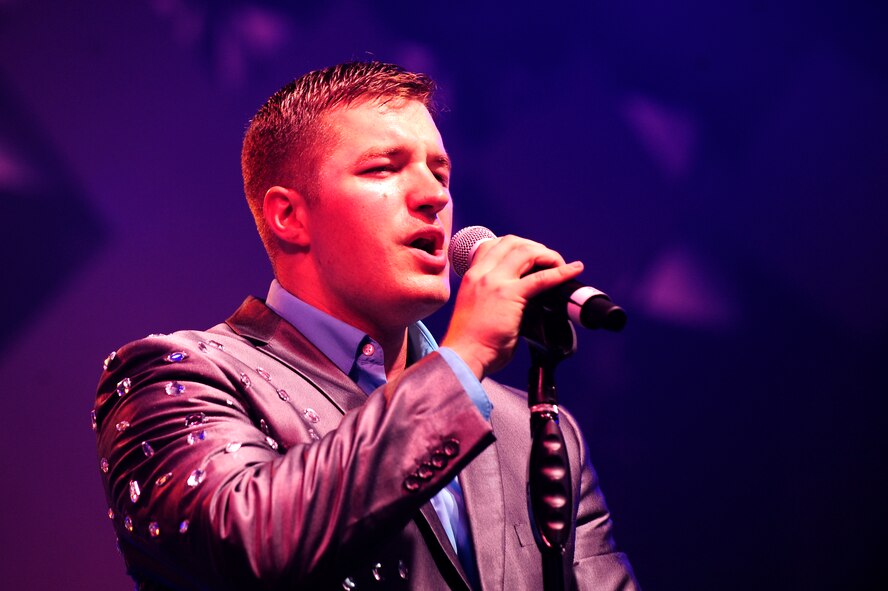 U.S. Air Force Senior Airman Jeremy Karcher, Tops in Blue vocalist, sings to the crowd at the Keystone Theater on Kadena Air Base, Japan, July 22, 2015. Tops in Blue serves as an expeditionary entertainment unit tasked with providing quality entertainment for the worldwide Air Force family. This year’s performance, “Freedom’s Song,” is being performed for service members and their families throughout the United States as well as 20 countries worldwide. (U.S. Air Force photo by Airman 1st Class Corey Pettis) 