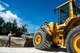 A U.S. Air Force Airman from the 18th Civil Engineer Squadron guides a U.S. Navy Sailor from Naval Mobile Construction Battalion 5 as he pushes debris into a crater during joint airfield damage repair training on Kadena Air Base, Japan, July 23, 2015. The training gave U.S. Air Force and Navy participants the opportunity to gain familiarity with one another while practicing skills they could potential implement in a wartime environment. (U.S. Air Force photo by Staff Sgt. Maeson L. Elleman)