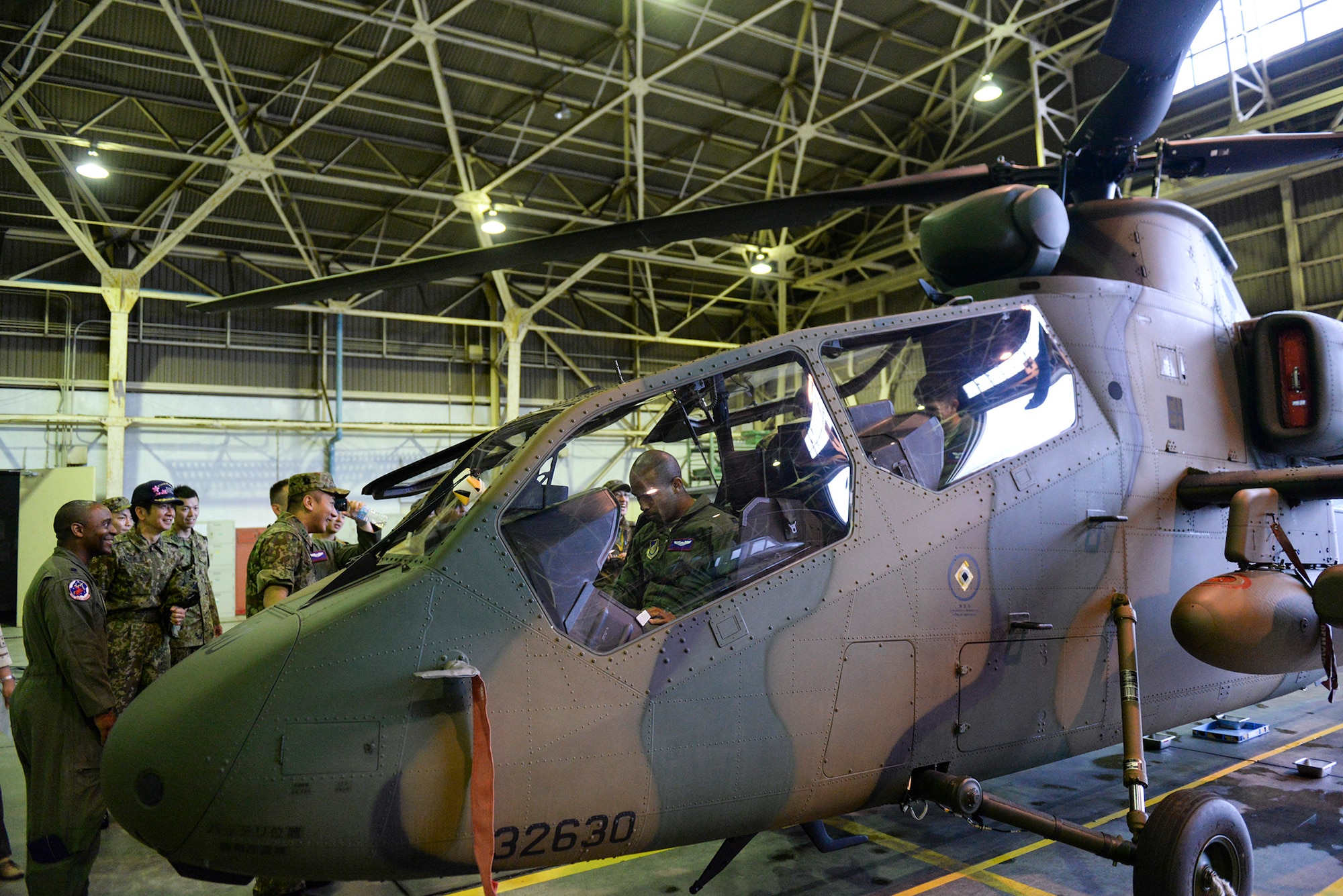 Aircrew members with the 459th Airlift Squadron take seats in an OH-1 Omega helicopter at Tachikawa Air Base, Japan, July 16, 2015. The OH-1, which was part of a static display hosted by Japan Ground Self-Defense Force, is the first helicopter designed and manufactured in Japan. (U.S. Air Force photo by Airman 1st Class Elizabeth Baker/Released)