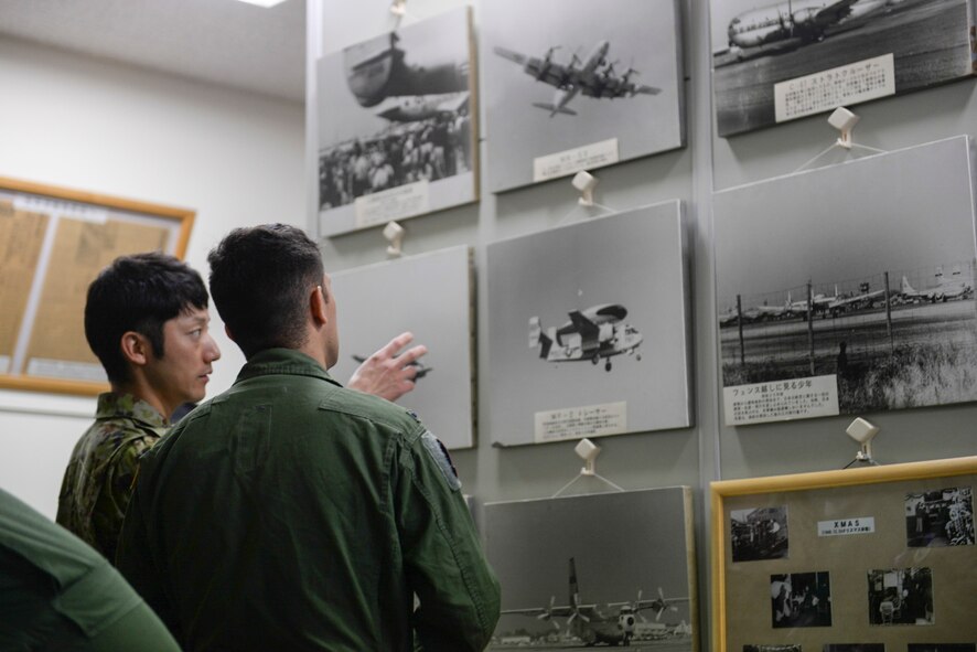 Sgt. Miyauchi with the Japan Ground Self-Defense Force explains photographs to an Airman from the 459th Airlift Squadron at Tachikawa Air Base, Japan, July 16, 2015. JGSDF talked to aircrew from the 459 AS about Japan’s history of military flight in Tachikawa AB’s heritage museum. (U.S. Air Force photo by Airman 1st Class Elizabeth Baker/Released)