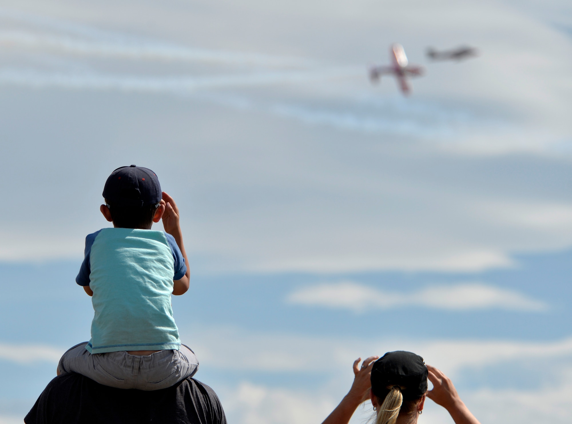 Liam Schuler, 5, waves as two Harvard perform at the 2015 Lethbridge International Airshow July 25, 2015, in Lethbridge, Alberta province, Canada. The airshow featured performances and static displays from more than 10 aircraft.  (U.S. Air Force photo by Airman 1st Class Christian Clausen/Released)

