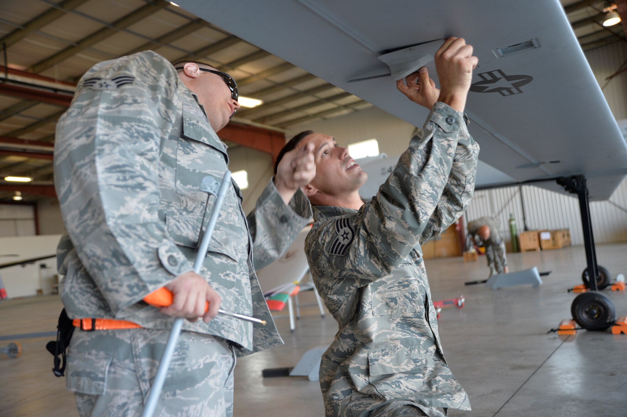 Senior Airman Derek Lee, 432nd Aircraft Maintenance Squadron avionics technician and Staff Sgt. Craig Stewart, 432nd AMXS MQ-1 Predator crew chief, assemble an MQ-1 Predator static display July 24, 2015, in Lethbridge, Alberta province, Canada. The MQ-1 Predator is a multi-role aircraft used for intelligence, surveillance, and reconnaissance primarily and can also be used for kinetic strikes.  (U.S. Air Force photo by Airman 1st Class Christian Clausen/Released)