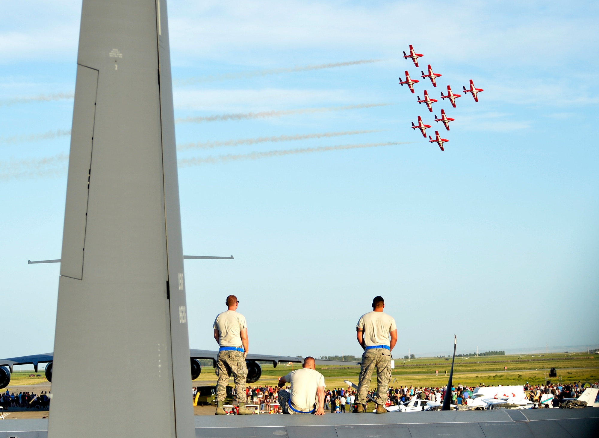 Airmen from the 415th Special Operations Squadron stand on top of a C-130 Hercules to watch the Royal Canadian Forces Snowbirds perform July 24, 2015, in Lethbridge, Alberta province, Canada. The C-130 static display and Snowbird performance were part of the 2015 Lethbridge International Airshow.  (U.S. Air Force photo by Airman 1st Class Christian Clausen/Released)
