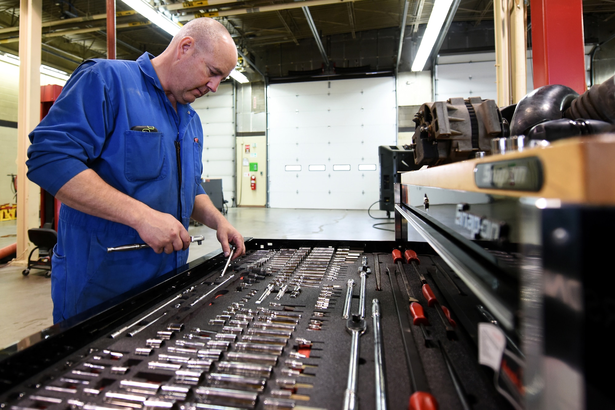 Bob Anderson, 341st Logistics Readiness Squadron truck and tractor shop vehicle mechanic, chooses specific tools from an individual tool kit to work on a maintenance van engine July 27, 2015, at Malmstrom Air Force Base, Mont. The 341st LRS truck tractor maintenance shop maintains all semi trucks and trailers on base. (U.S. Air Force photo/Chris Willis)